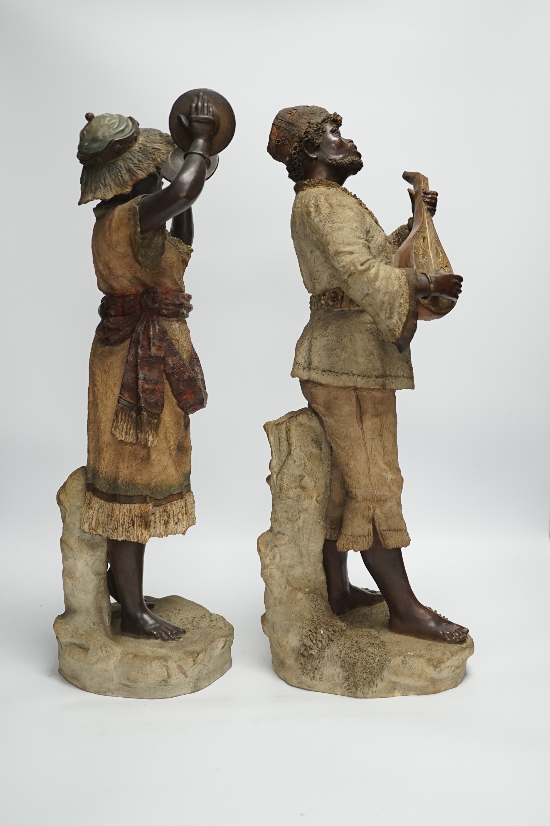 A pair of late 19th century Continental cold painted terracotta Nubian musician figures, 49cm